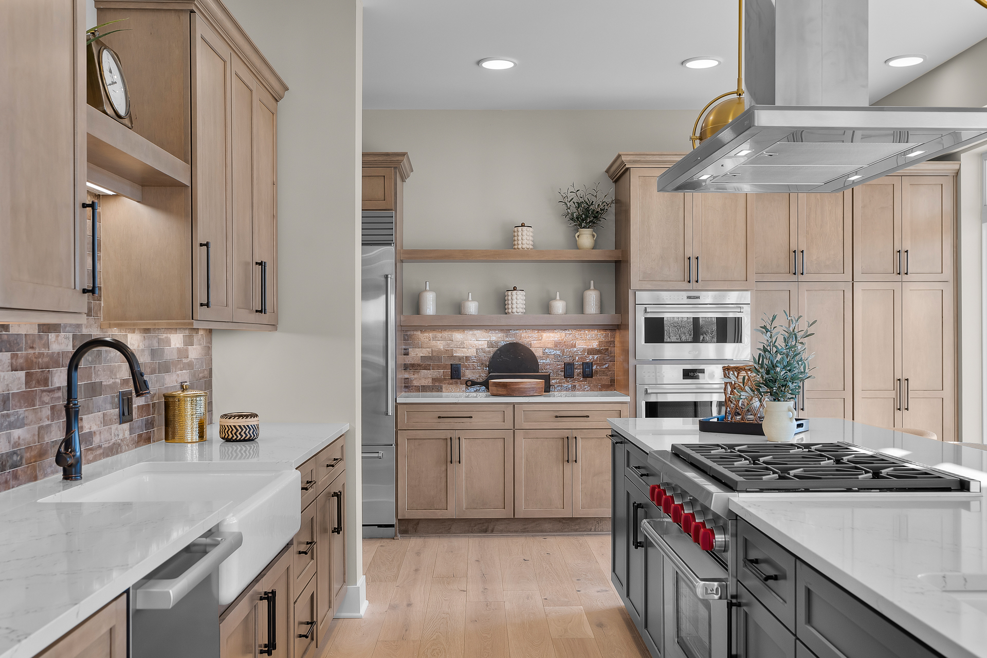 spacious modern kitchen with white countertops, chef's cooktop, modern hardware